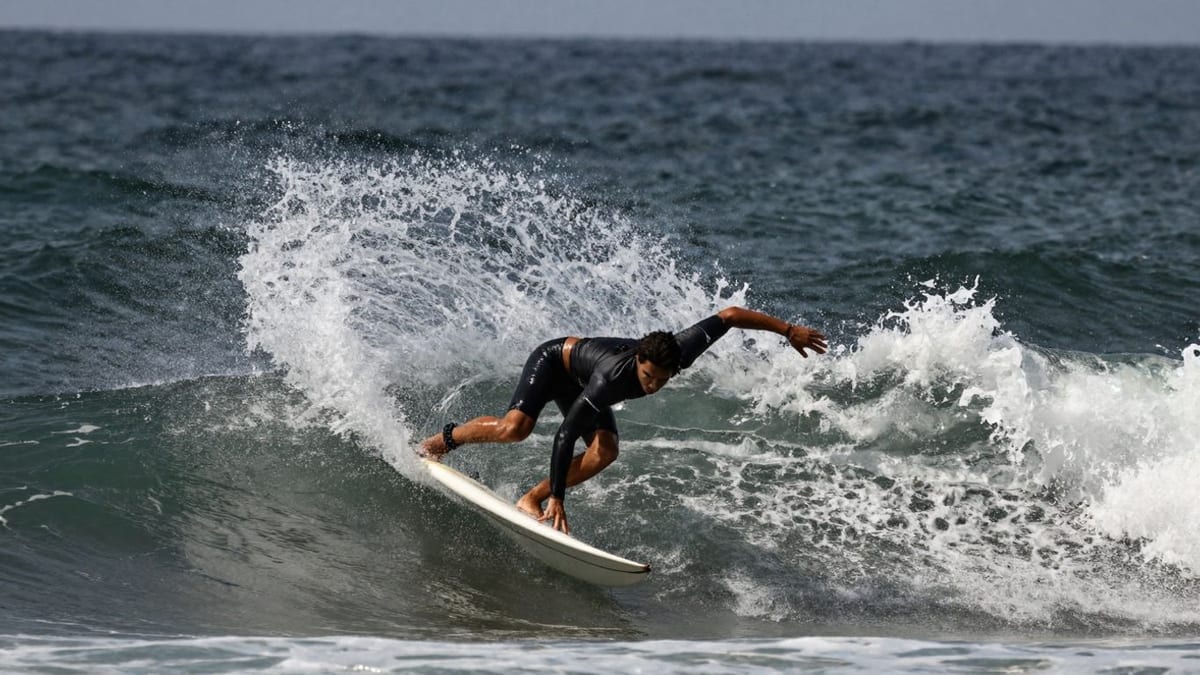 Surfer macht eine Bottom Turn auf einer Welle