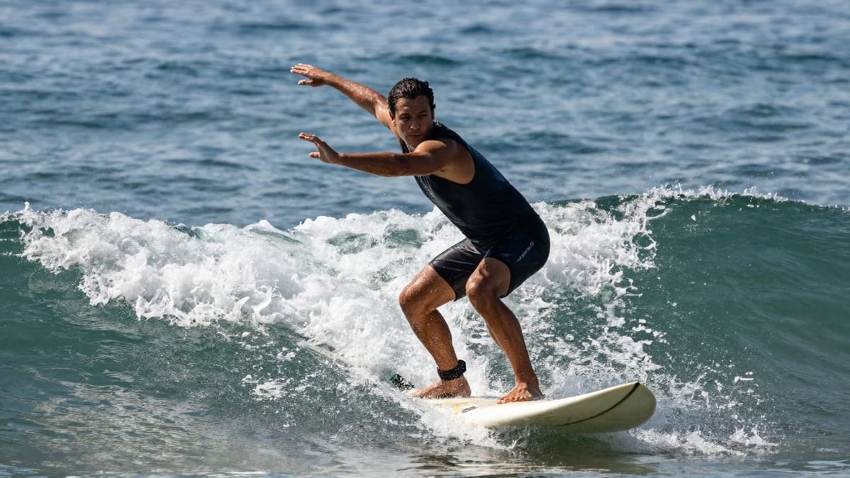 Surfer dehnt Schultern am Meer